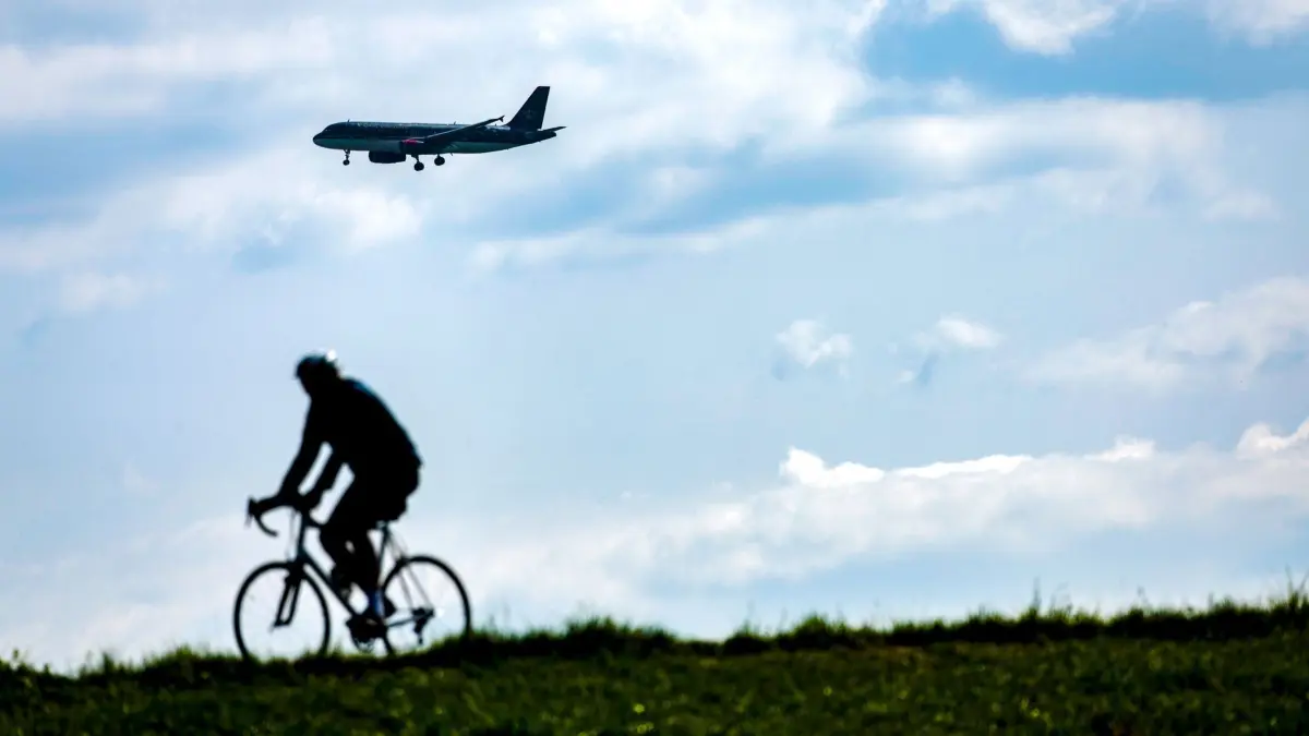 Wetter in Düsseldorf: 19.04.2025, Nordrhein-Westfalen, Düsseldorf: Ein Radfahrer fährt bei Sonnenschein auf dem Rheindeich. Foto: Thomas Banneyer/dpa +++ dpa-Bildfunk +++