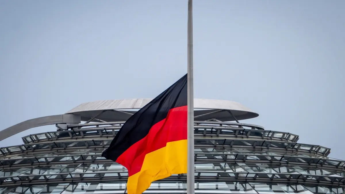 Papst Franziskus gestorben - Flagge auf Halbmast - Berlin: 22.04.2025, Berlin: Eine der Deutschland-Flaggen auf dem Reichstag weht am Morgen vor der Kulisse der Reichstagskuppel auf Halbmast. Bundesinnenministerin Faeser hat wegen des Todes von Papst Franziskus für den 22. April 2025 die Trauerbeflaggung der obersten Bundesbehörden angeordnet. Foto: Soeren Stache/dpa +++ dpa-Bildfunk +++