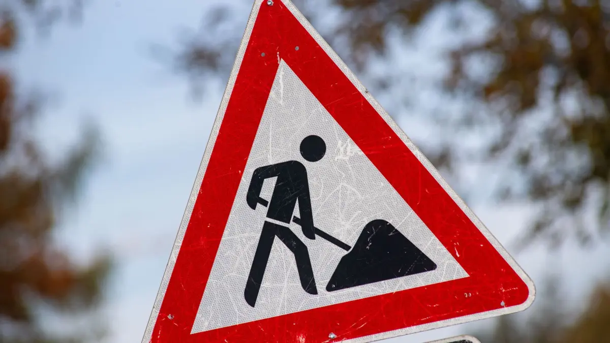 Ein zerkratztes Schild Gefahrzeichen Arbeitsstelle (Zeichen 123) mit dem Piktogramm eines Bauarbeiters zur Beschilderung einer Baustelle steht in der Gemeinde Sauzin auf der Insel Usedom. (zu dpa: «Straßensperrung nach Hangrutsch») +++ dpa-Bildfunk +++