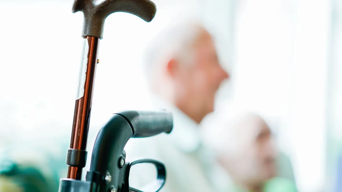 Wohnen im Alter: ARCHIV - 05.08.2019, Rheinland-Pfalz, Neuburg: Der Handgriff eines Rollators und ein Gehstock sind zu sehen. (zu dpa: «Landesprogramm «Saar66» will Pflegebedürftigkeit reduzieren») Foto: Uwe Anspach/dpa +++ dpa-Bildfunk +++