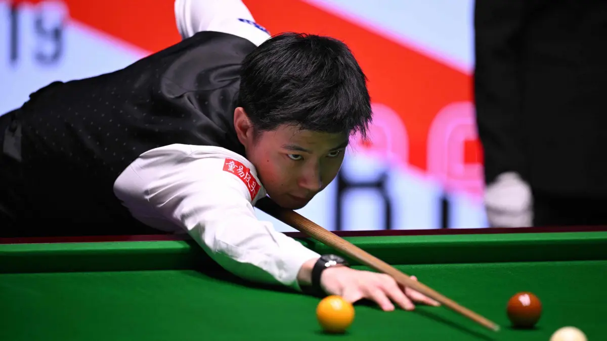 China's Zhao Xintong plays a shot on day two of his World Championship Snooker final against Wales' Mark Williams during the afternoon session at The Crucible in Sheffield, northern England on May 5, 2025. (Photo by Oli SCARFF / AFP)
