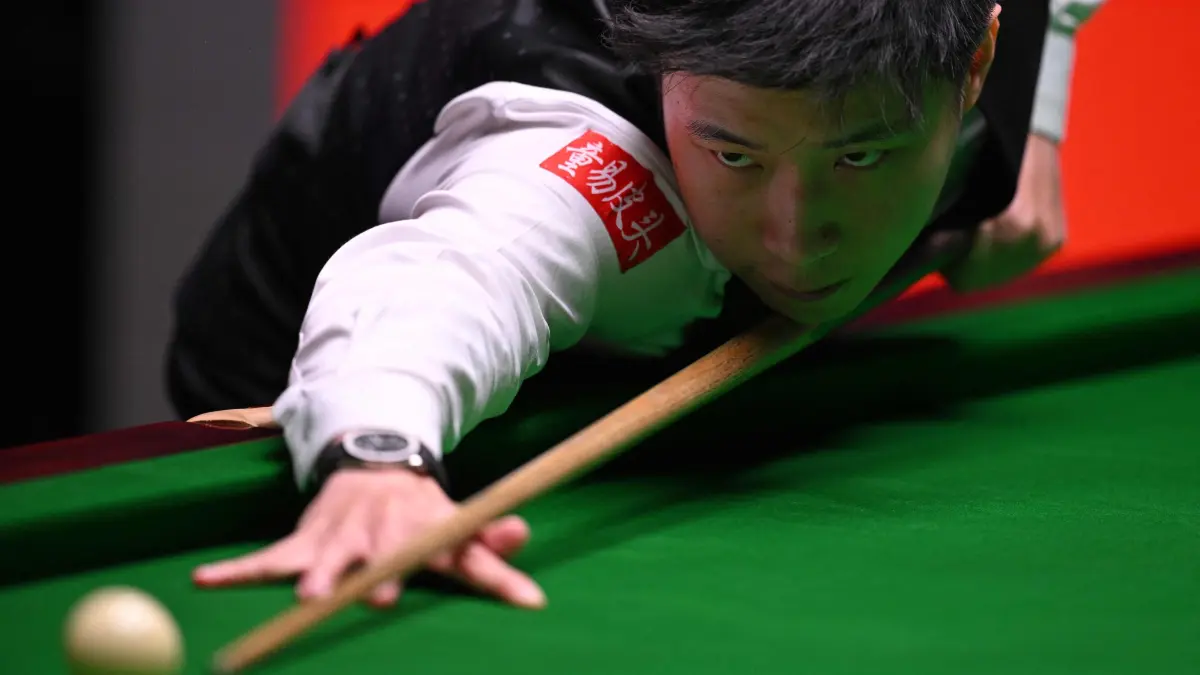 China's Zhao Xintong plays a shot on day two of his World Championship Snooker final against Wales' Mark Williams during the afternoon session at The Crucible in Sheffield, northern England on May 5, 2025. (Photo by Oli SCARFF / AFP)