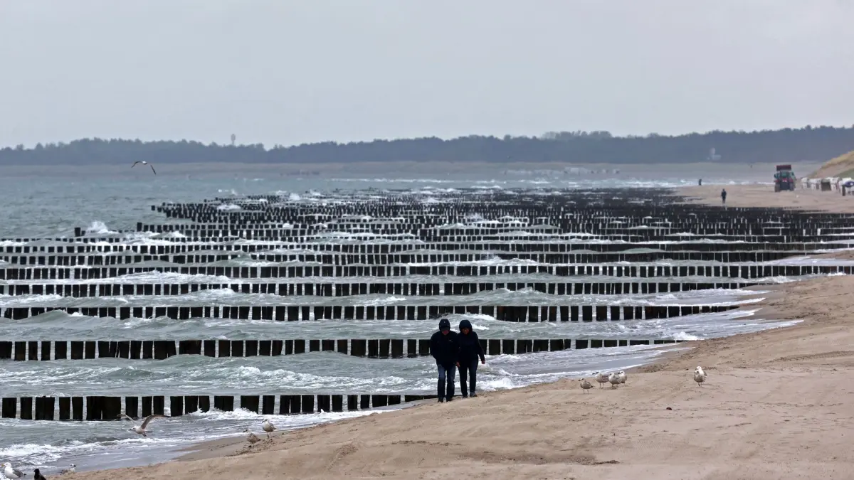 Graues Wetter im Norden: 06.05.2025, Mecklenburg-Vorpommern, Graal-Müritz: Nur wenige Spaziergänger sind am Ostseestrand unterwegs. Trübes und graues Wetter dominiert im Norden. Foto: Bernd Wüstneck/dpa +++ dpa-Bildfunk +++