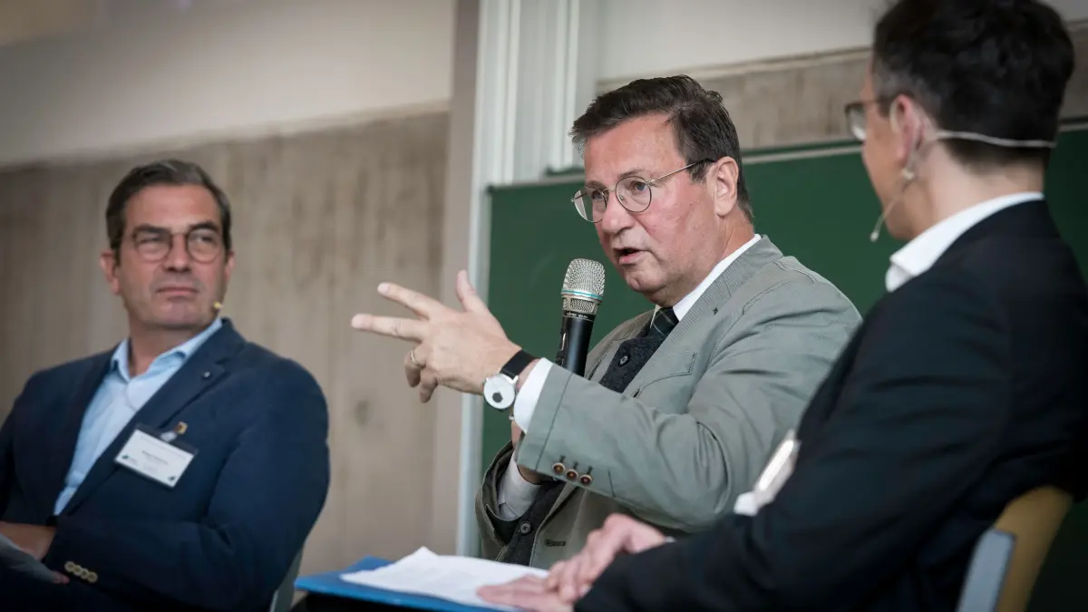 Auf dem Podium von links: Jürgen Scheurer (Geschäftsführer Plattform Erneuerbare Energien), Minister Peter Hauck und Prof. Harald Thorwarth.