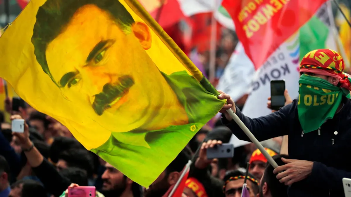 Fahne mit Bild von PKK-Chef Öcalan: ARCHIV - 21.03.2018, Türkei, Istanbul: Ein Jugendlicher hält eine Fahne mit dem Bild des inhaftierten Anführers der verbotenen kurdischen Arbeiterpartei PKK, Öcalan. (zu dpa: «PKK kündigt historische Entscheidung an - Auflösung?») Foto: Lefteris Pitarakis/AP/dpa +++ dpa-Bildfunk +++