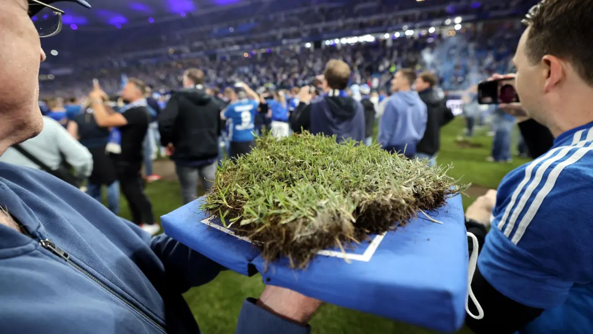 Hamburger SV - SSV Ulm 1846: 11.05.2025, Hamburg: Fußball: 2. Bundesliga, Hamburger SV - SSV Ulm 1846, 33. Spieltag, Volksparkstadion. Fans tragen ein Stück Rasen und feiern den Aufstieg in die 1. Bundesliga. WICHTIGER HINWEIS: Gemäß den Vorgaben der DFL Deutsche Fußball Liga bzw. des DFB Deutscher Fußball-Bund ist es untersagt, in dem Stadion und/oder vom Spiel angefertigte Fotoaufnahmen in Form von Sequenzbildern und/oder videoähnlichen Fotostrecken zu verwerten bzw. verwerten zu lassen. Foto: Christian Charisius/dpa +++ dpa-Bildfunk +++