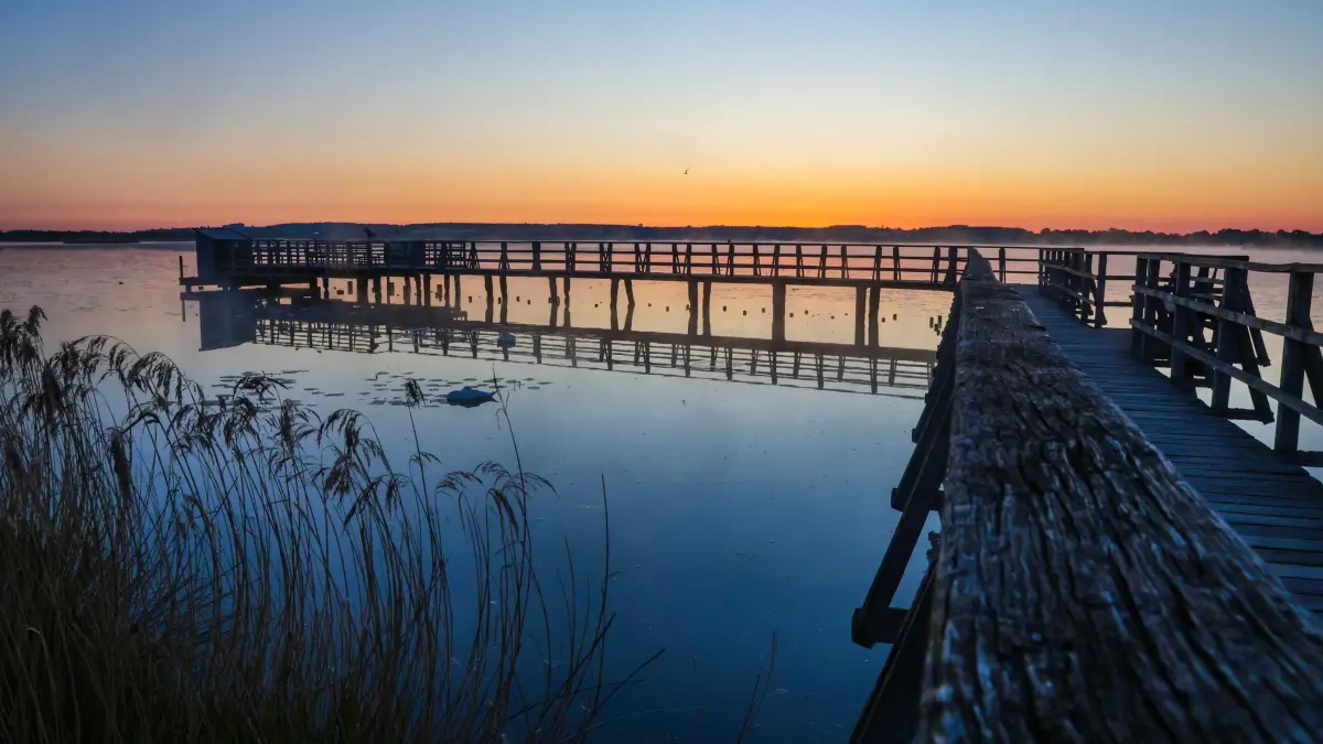 Wetter in Baden-Württemberg: 11.05.2025, Baden-Württemberg, Bad Buchau: Blick am Morgen vor Sonnenaufgang vom 1,5 Kilometer langen Federseesteg auf den Federsee. Der Federsee bei Bad Buchau in Oberschwaben (Landkreis Biberach) ist mit einer Fläche von 1,4 Quadratkilometer der zweitgrößte See in Baden-Württemberg. Foto: Thomas Warnack/dpa +++ dpa-Bildfunk +++