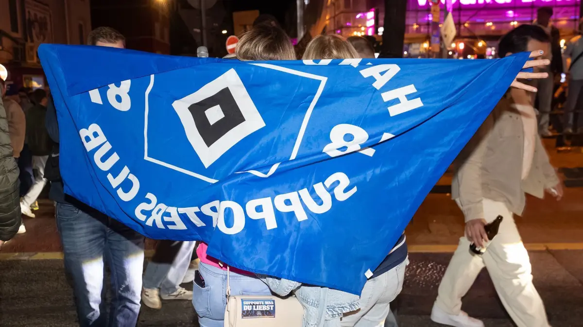 HSV-Fans feiern Aufstieg: 11.05.2025, Hamburg: Fans des Hamburger SV (HSV) feiern nach dem Sieg gegen den SSV Ulm auf der Reeperbahn auf St. Pauli. Foto: Bodo Marks/dpa - WICHTIGER HINWEIS: Gemäß den Vorgaben der DFL Deutsche Fußball Liga bzw. des DFB Deutscher Fußball-Bund ist es untersagt, in dem Stadion und/oder vom Spiel angefertigte Fotoaufnahmen in Form von Sequenzbildern und/oder videoähnlichen Fotostrecken zu verwerten bzw. verwerten zu lassen. +++ dpa-Bildfunk +++