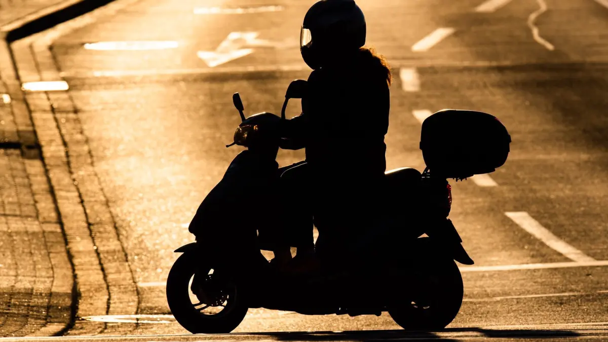 Motorroller im Gegenlicht: ILLUSTRATION - Idylle und Freiheit auf dem Motorroller? Mag sein, aber auf dem Zweirad kann es auch plötzlich sehr gefährlich werden. (zu dpa: «Roller-Unfall nach Fahrt über gelbe Ampel: Wer haftet?») Foto: Julian Stratenschulte/dpa/dpa-tmn - Honorarfrei nur für Bezieher des dpa-Themendienstes +++ dpa-Themendienst +++
