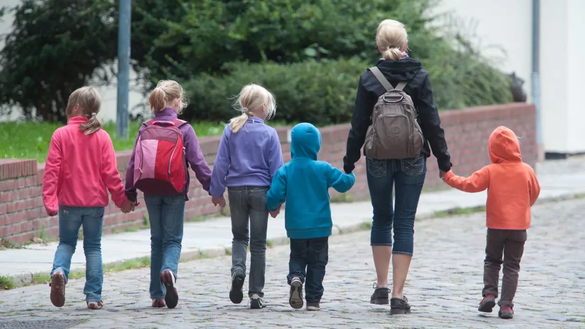 ARCHIV - ILLUSTRATION - Eine Frau und Kinder gehen am 09.08.2011 durch die Altstadt von Stralsund an der Ostsee. Der Bundesgerichtshof (BGH) in Karlsruhe entscheidet am Freitag (13.07.), ob eine Tagesmutter in einem Wohnhaus fremde Kinder betreuen oder ihr die Hausgemeinschaft dies verbieten kann. Foto: Stefan Sauer dpa +++(c) dpa - Bildfunk+++