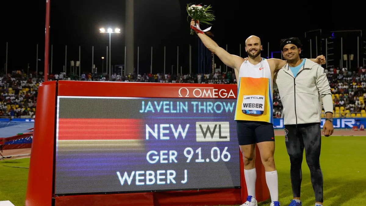 Germany's Julian Weber celebrates his world leading score with India's Neeraj Chopra (R) after the men's Javelin throw final during the IAAF Diamond League competition at the Suheim Bin Hamad Stadium in Doha on May 16, 2025. (Photo by Karim JAAFAR / AFP)
