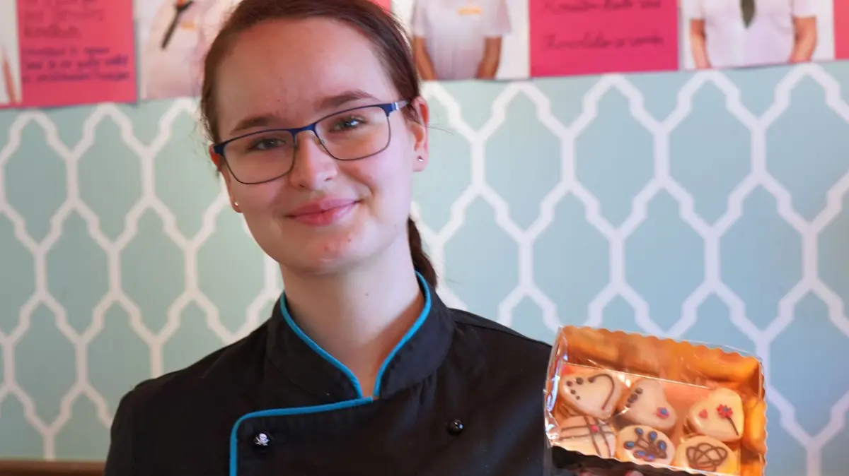 Hanna Schiebel präsentiert Teegebäck, eine der süßen Köstlichkeiten, die die Auszubildenden im Rahmen des zweiwöchigen Projekts "Azubi-Filiale" in Eigenregie herstellen.
