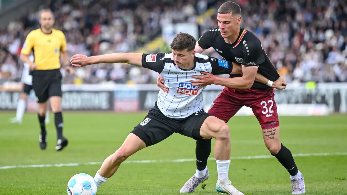 SSV Ulm 1846 - Preußen Münster: 18.05.2025, Baden-Württemberg, Ulm: Fußball: 2. Bundesliga, SSV Ulm 1846 - Preußen Münster, 34. Spieltag, Donaustadion. Ulms Semir Telalovic (l) in Aktion gegen Münsters Luca Bazzoli (r). Foto: Harry Langer/dpa - WICHTIGER HINWEIS: Gemäß den Vorgaben der DFL Deutsche Fußball Liga bzw. des DFB Deutscher Fußball-Bund ist es untersagt, in dem Stadion und/oder vom Spiel angefertigte Fotoaufnahmen in Form von Sequenzbildern und/oder videoähnlichen Fotostrecken zu verwerten bzw. verwerten zu lassen. +++ dpa-Bildfunk +++