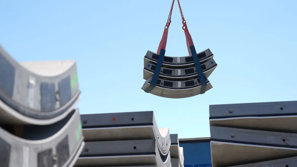 Baustelle Suedlink-Elbquerung ElbX: 20.05.2025, Schleswig-Holstein, Wewelsfleth: Tübbinge, Bauteile der Außenschale des Tunnels, werden mit einem Kran auf der Baustelle Suedlink-Elbquerung ElbX bewegt. Rund 850 Meter des 5,2 Kilometer langen Tunnels seien gebohrt. Der Abschnitt unter der Elbe der Stromleitung Suedlink soll 2027 fertiggestellt sein. Suedlink soll auf rund 700 Kilometern Strom des Netzbetreibers Tennet zwischen Norden und Süden transportieren. Foto: Marcus Brandt/dpa +++ dpa-Bildfunk +++