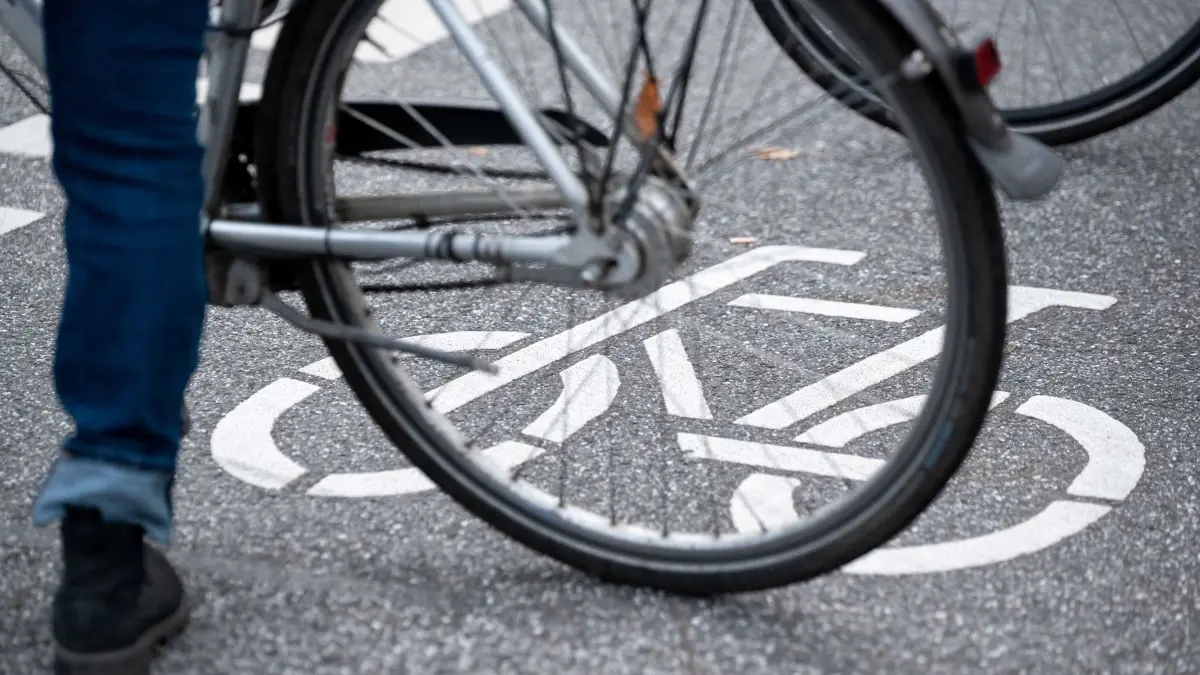 Ein Fahrrad-Symbol ist auf der Fahrbahn einer Straße hinter einem Fahrrad zu sehen. Dutzende Menschen haben an einem "Die-In" für den am vergangenen Freitag von einem Lastwagen überrollten und dabei tödlich verletzten Radfahrer teilgenommen und sich mit ihren Fahrrädern für fünf Minuten auf die Unfallkreuzung gelegt. (zu dpa: «Betrunkener Fahrradfahrer bei Unfall verletzt») +++ dpa-Bildfunk +++
