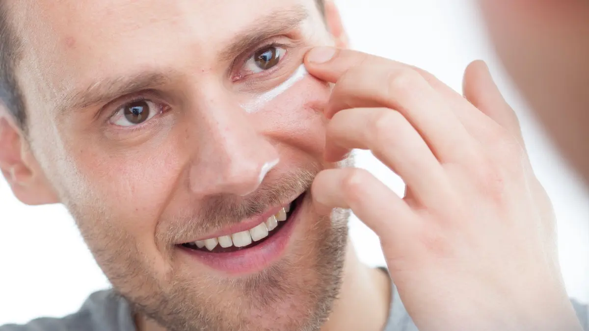 Mann cremt sein Gesicht ein: ILLUSTRATION - Welche Gesichtscreme geeignet ist, hängt vom Hauttyp ab. (zu dpa: «Skincare-Routine: Zum frischen Teint in 5 Schritten») Foto: Christin Klose/dpa-tmn - Honorarfrei nur für Bezieher des dpa-Themendienstes +++ dpa-Themendienst +++