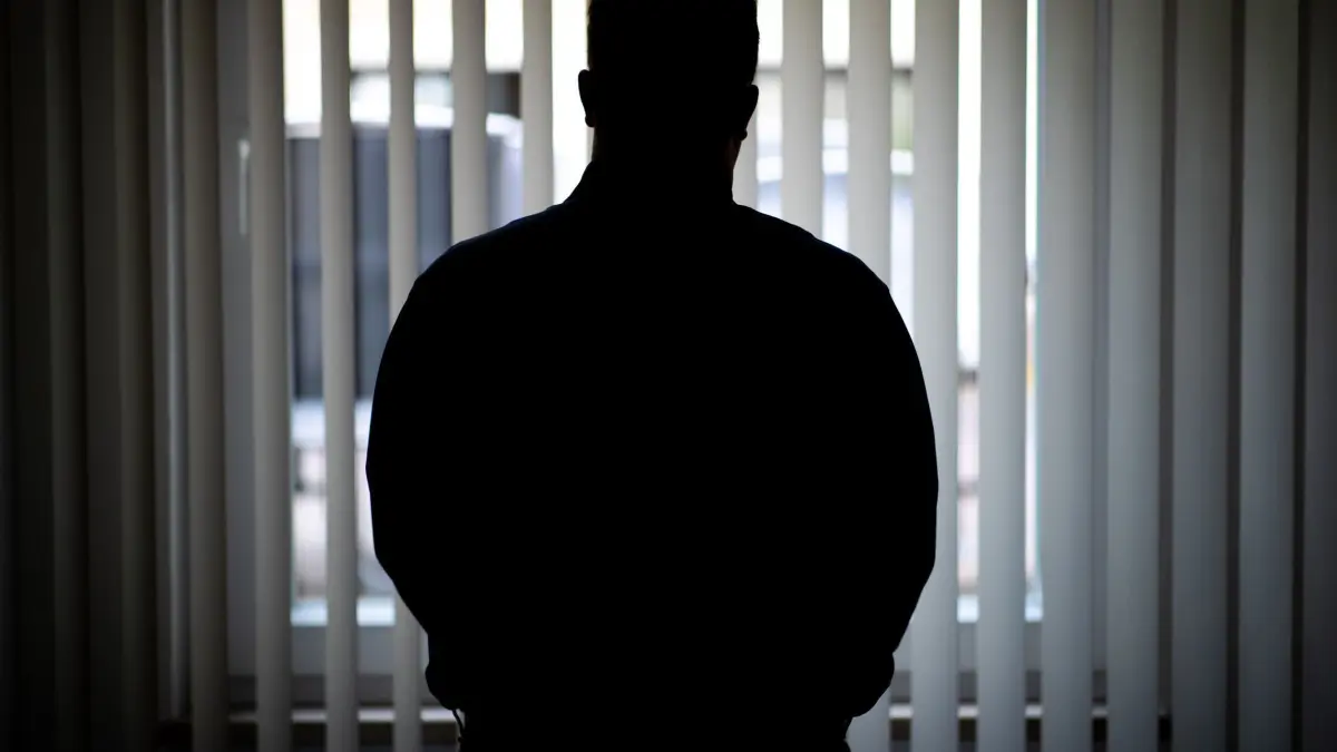 Ein Mann blickt aus einem Fenster: ILLUSTRATION - Scham und Stereotype verhindern Hilfe: Viele Männer sprechen nicht über ihre Erfahrungen aus Angst, nicht ernst genommen zu werden. Doch es gibt Hilfe. (zu dpa: «Beziehungsgewalt: Wenn Männer Opfer sind») Foto: Daniel Karmann/dpa - Honorarfrei nur für Bezieher des dpa-Themendienstes +++ dpa-Themendienst +++