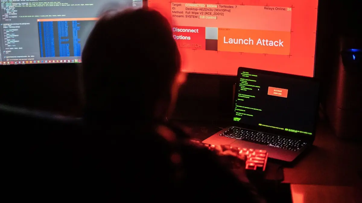 ARCHIV - 25.02.2022, Nordrhein-Westfalen, Bad Oeynhausen: ILLUSTRATION - Ein Mann sitzt vor Bildschirmen, die Hacker-Programme und eine fiktive Fernlösch-Software zeigen. Die Furcht vor einem kriminellen Cyberangriff bleibt trotz hoher Inflation, Energiesorgen und Ukraine-Kriegs die größte Sorge für Manager und Sicherheitsfachleute. (Zu dpa «Allianz: Cyberkriminalität bleibt größte Gefahr für Unternehmen») Foto: Lino Mirgeler/dpa +++ dpa-Bildfunk +++