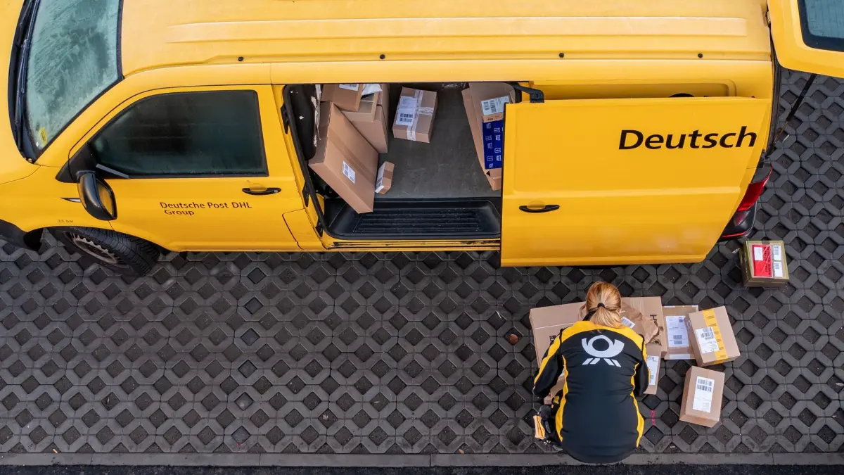 Eine Mitarbeiterin der Deutsche Post DHL belädt ihr Fahrzeug mit Päckchen und Paketen. Die Wochen vor Weihnachten bedeutet traditionell Hochbetrieb bei den Logistikunternehmen. Tage mit Rabattaktionen wie dem Black Friday steigern das Paketaufkommen zusätzlich. (Luftaufnahme mit Drohne) +++ dpa-Bildfunk +++