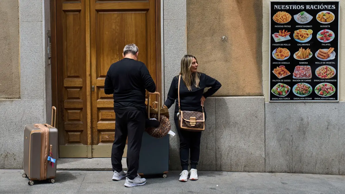 Spannungen am Wohnungsmarkt in Spanien: 03.06.2025, Spanien, Madrid: Touristen warten am Eingang eines Gebäudes in der Innenstadt. Die spanische Regierung hatte Mitte Mai die Löschung von mehr als 65.000 Airbnb-Anzeigen für die Vermietung von Ferienwohnungen angeordnet. Foto: Bernat Armangue/AP/dpa +++ dpa-Bildfunk +++