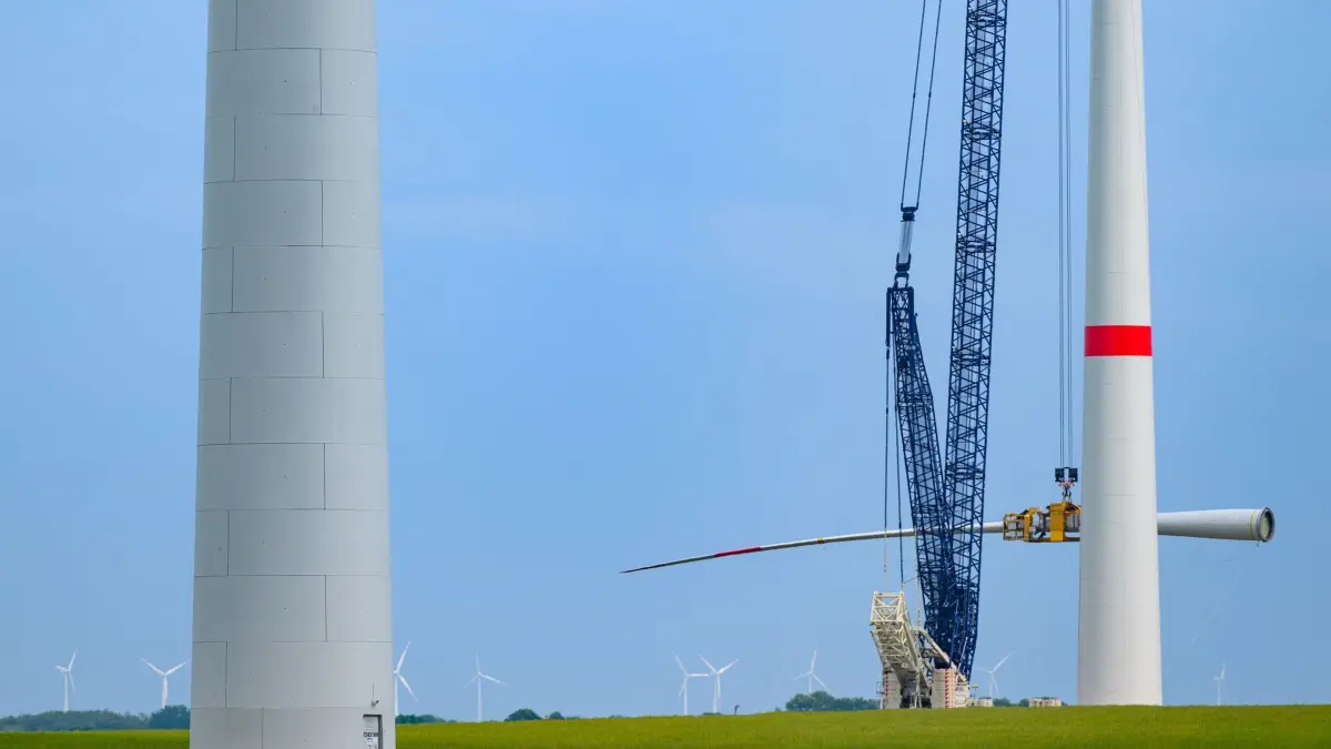 Ausbau von Windenergie: 02.06.2025, Brandenburg, Lebus: Ein Rotorblatt wird an einer neuen Windenergieanlage mit Hilfe eines Krans montiert. Nach Auskunft vom Bundesverband WindEnergie e.V. (BWE) nimmt das Binnenland Brandenburg den zweiten Platz in der Rangliste der Bundesländer mit der größten installierten Leistung bei Windenergieanlagen ein. So wird gut ein Drittel des Strombedarfs aus Wind gewonnen. Mit rund 9000 MegaWatt (MW) installierter Gesamtleistung nimmt Brandenburg heute nach Niedersachsen den zweiten Platz ein. Foto: Patrick Pleul/dpa/ZB - Honorarfrei nur für Bezieher des Dienstes ZB-Funkregio Ost +++ ZB-FUNKREGIO OST +++