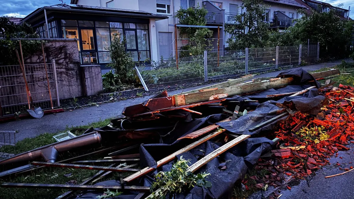 Nach dem Unwetter in Baden-Württemberg - Langenau: 04.06.2025, Baden-Württemberg, Langenau: Nach dem Unwetter im Alb-Donau-Kreis liegen Dachrinnen, Holzbalken und kaputte Dachziegel auf einer Straße. Sturmböen, Starkregen und heftige Gewitter waren zuvor über weite Teile Baden-Württembergs hinweggezogen. Foto: Sven Grundmann/News5/dpa +++ dpa-Bildfunk +++
