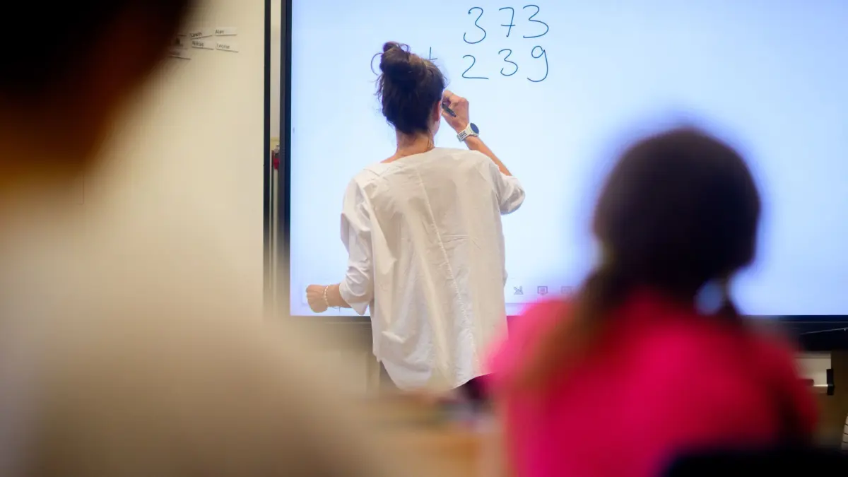 Mathematik-Unterricht: ARCHIV - 17.08.2023, Niedersachsen, Hannover: Eine Lehrerin schreibt eine Mathematikaufgabe auf eine digitale Schultafel im Klassenraum einer 4. Klasse einer Grundschule. (zu dpa: «Studie: Zwei Drittel der Lehrer leisten unbezahlt Mehrarbeit») Foto: Julian Stratenschulte/dpa +++ dpa-Bildfunk +++