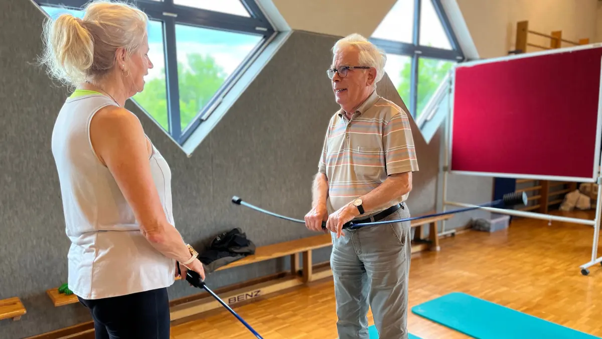 Gesundheitstag meets Lagerverkauf in Gaildorf, Besucher Hans-Heinrick Lübke mit Personal Fitnesstrainerin Barbara Gentner und dem Schwingstab