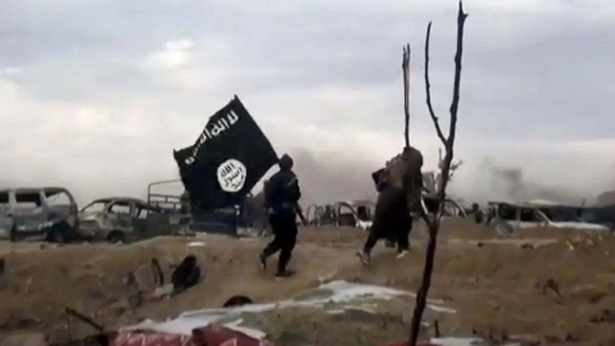 IS Propaganda: ARCHIV - 19.03.2019, Syrien, Baghus: IS-Kämpfer laufen mit einer IS-Flagge. (Screenshot aus einem Video der Amaq News Agency, dem Medienarm des Islamischen Staates - Beste verfügbare Qualität; Illustration zu "14-jähriger Kölner unter Terrorverdacht") Foto: Amaq News Agency/AP/dpa +++ dpa-Bildfunk +++