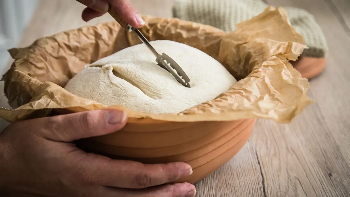 Sauerteig Weizenbrot im Römertopf backen: ILLUSTRATION - Sauerteig für Weizenbrot kann im Römertopf gebacken werden und wird vor dem Backen eingeschnitten. (zu dpa: «Selbst gezüchtet: Brotbacken mit dem eigenen Sauerteig») Foto: Christin Klose/dpa-tmn - Honorarfrei nur für Bezieher des dpa-Themendienstes +++ dpa-Themendienst +++