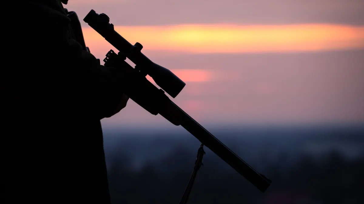 Jäger mit Waffe: ARCHIV - 20.02.2019, NA, Bielefeld: Ein Jäger hält sein Gewehr in der Abenddämmerung. (zu dpa: «Saar-Jäger erlegen mehr Wildschweine») Foto: Friso Gentsch/dpa +++ dpa-Bildfunk +++