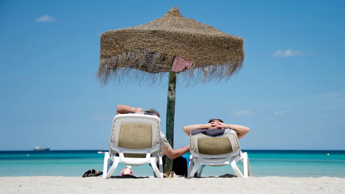 Urlauber liegen am Strand: ARCHIV - Ab in die Sonne: Auch Kurzentschlossene finden noch reichlich Angebote für Sommerurlaub am Meer. (zu dpa: «Sommerurlaub: Sparen auf den letzten Drücker») Foto: Julian Stratenschulte/dpa/dpa-tmn - Honorarfrei nur für Bezieher des dpa-Themendienstes +++ dpa-Themendienst +++