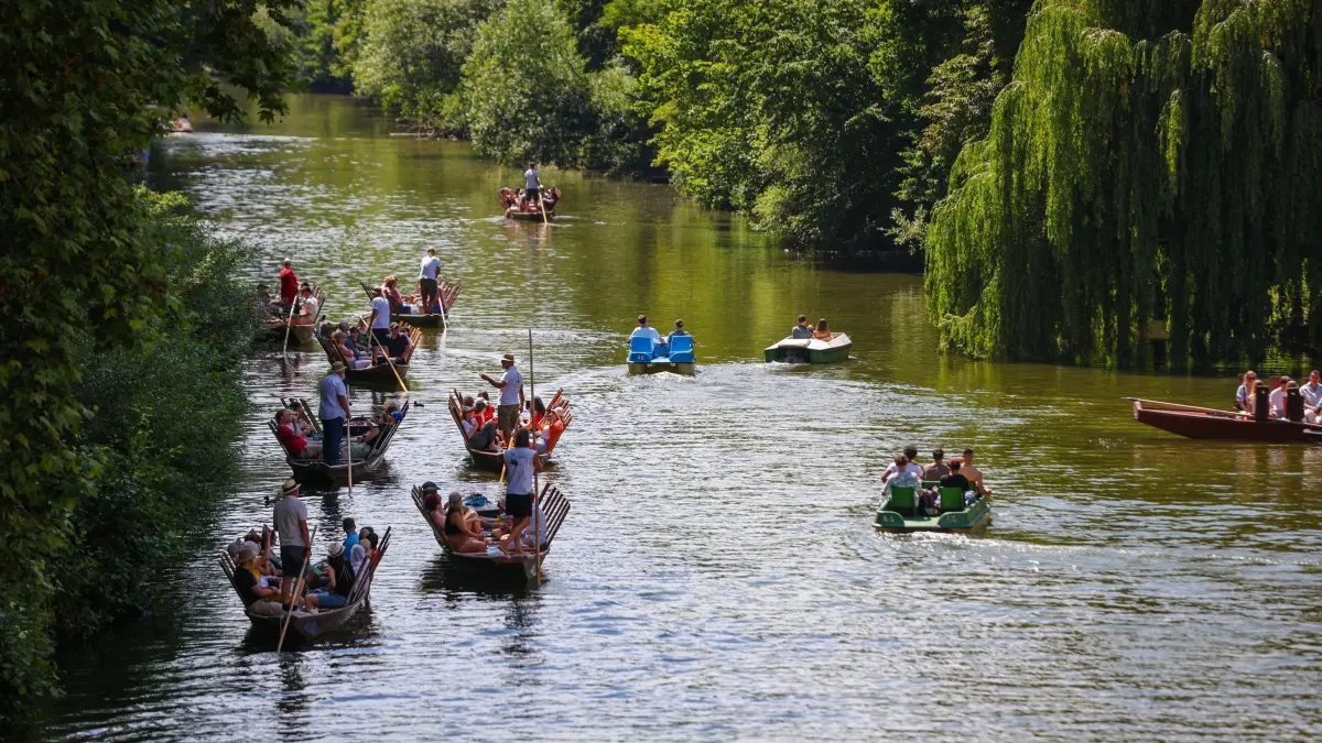 Sommerwetter in Baden-Württemberg: 21.06.2024, Baden-Württemberg, Tübingen: Menschen genießen mit Stocherkähnen und Tretbooten das Sommerwetter auf dem Neckar. Die Menschen im Land können sich auf ein sonniges Sommerwochenende mit Temperaturen bis zu 37 Grad am Sonntag freuen. Foto: Christoph Schmidt/dpa +++ dpa-Bildfunk +++
