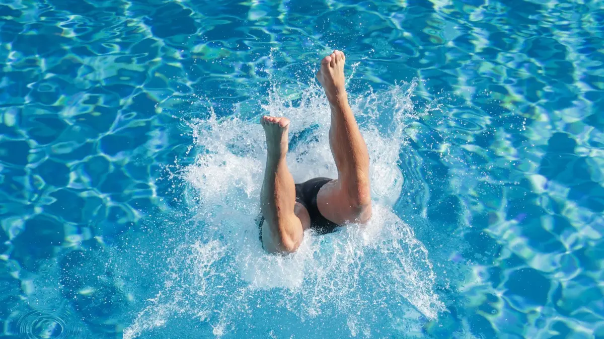 Sommerwetter in Baden-Württemberg: 22.06.2025, Baden-Württemberg, Sigmaringen: Ein Mann springt im Donaubad in das Wasserbecken. Foto: Thomas Warnack/dpa +++ dpa-Bildfunk +++