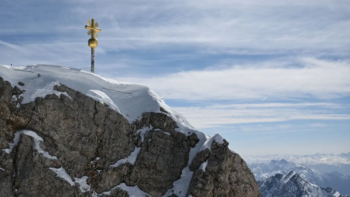 ARCHIV - 29.04.2024, Bayern, Grainau: Die im Tal restaurierten Strahlen des Gipfelkreuzes der Zugspitze wurden von Mitarbeitern wieder am Gipfelkreuz angebracht. (zu dpa: «Fleischlos auf der Zugspitze - Restaurant stellt um») Foto: Angelika Warmuth/dpa +++ dpa-Bildfunk +++