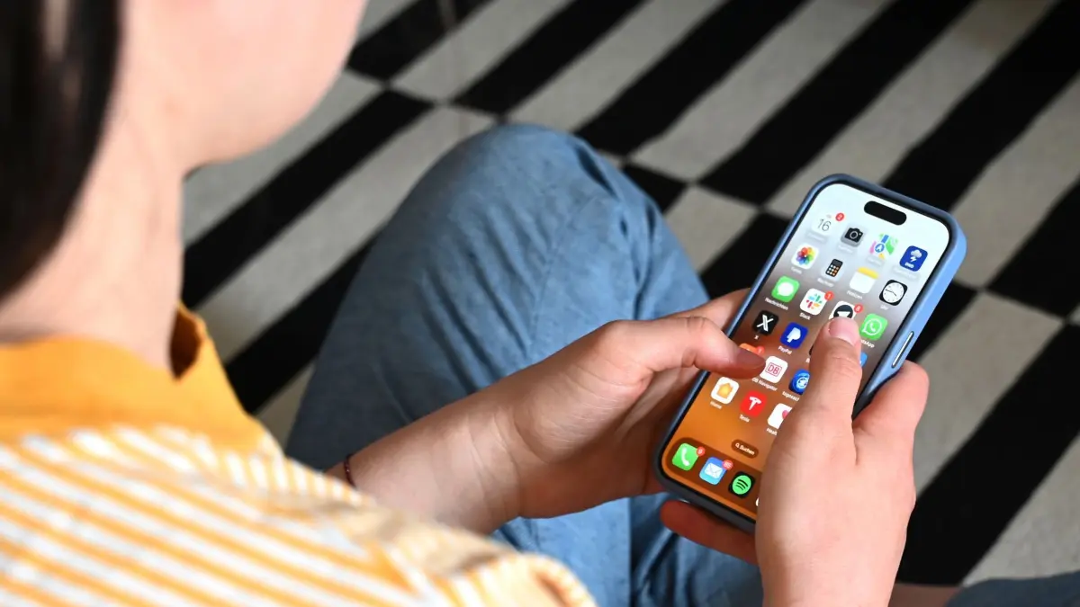 Smartphone-Nutzung bei Jugendlichen: SYMBOLBILD - 17.05.2025, Sachsen, Leipzig: Eine Jugendliche sitzt auf dem Boden und nutzt ein Smartphone - auf dem Display sind verschiedene Apps zu sehen. Ob Social Media, Chats oder Spiele: Das Smartphone ist zentraler Bestandteil der digitalen Freizeitgestaltung vieler Jugendlicher. (zu dpa: «Wie viel Zeit verbringen Kinder und Jugendliche am Handy?») Foto: Elisa Schu/dpa +++ dpa-Bildfunk +++