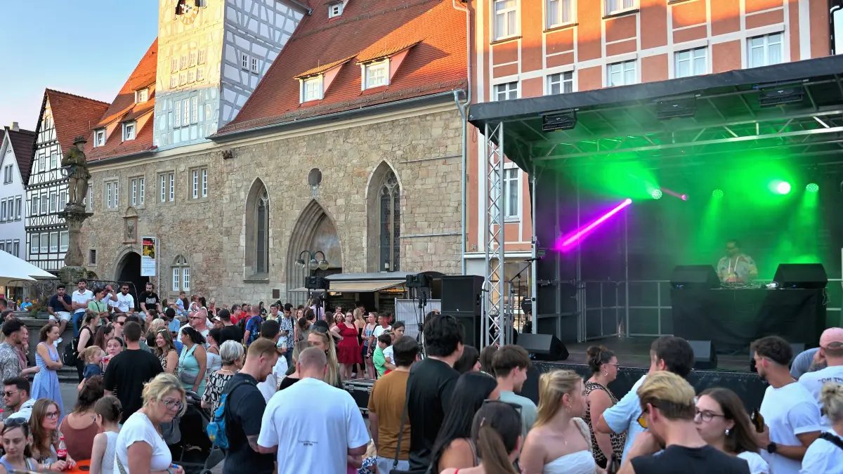 Guten Laune und satter Andrang: Festivalstimmung mit Laserlicht und einen leuchtenden Sonnenuntergang vor der Kulisse des Spitalhofs.