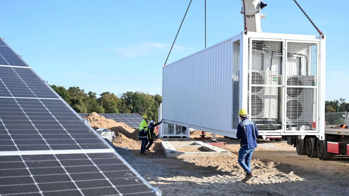 13.10.2023, Baden-Württemberg, Bruchsal: An einem fast fertigen Solarpark des Energieversorgers EnBW wird ein Batteriespeicher angeliefert. Insgesamt wurden dort zwei aufgestellt. EnBW will künftig grundsätzlich Batteriespeicher in neu geplante Solarparks einbauen. Damit setzt der Konzern eigenen Worten zufolge als erstes Energieunternehmen in Deutschland standardmäßig auf solche Speicher in Solarparks. Foto: Uli Deck/dpa +++ dpa-Bildfunk +++