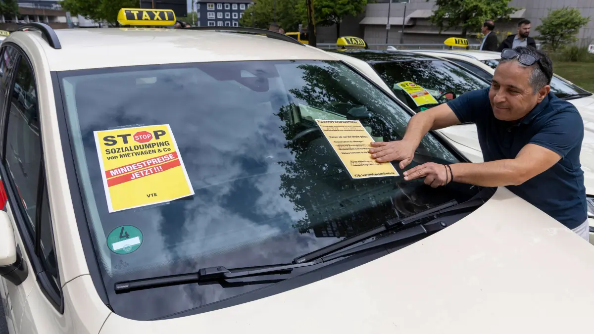 Taxifahrer Demonstration. : Taxifahrer Demonstration. 09.07.2025, EU, DEU, Deutschland, Nordrhein-Westfalen, Essen: ein Demonstrationskorso von Taxen fährt von der Messe bis zum Rathaus. Mit dieser Demonstration wollen die Taxiunternehmen Druck auf die Stadtverwaltung ausüben. Sie fordern von dieser die Einführung von Mindesttarifen für Mietwagen sowie mehr Kontrollen, da immer mehr Taxibetriebe durch die Dumpingpreise von Mietwagenanbietern wie Uber in ihrer Existenz bedroht sind. A demonstration procession of cabs travels from the trade fair to the town hall. With this demonstration, the cab companies want to put pressure on the city council. They are demanding the introduction of minimum tariffs for hire cars and more controls, as more and more cab companies a