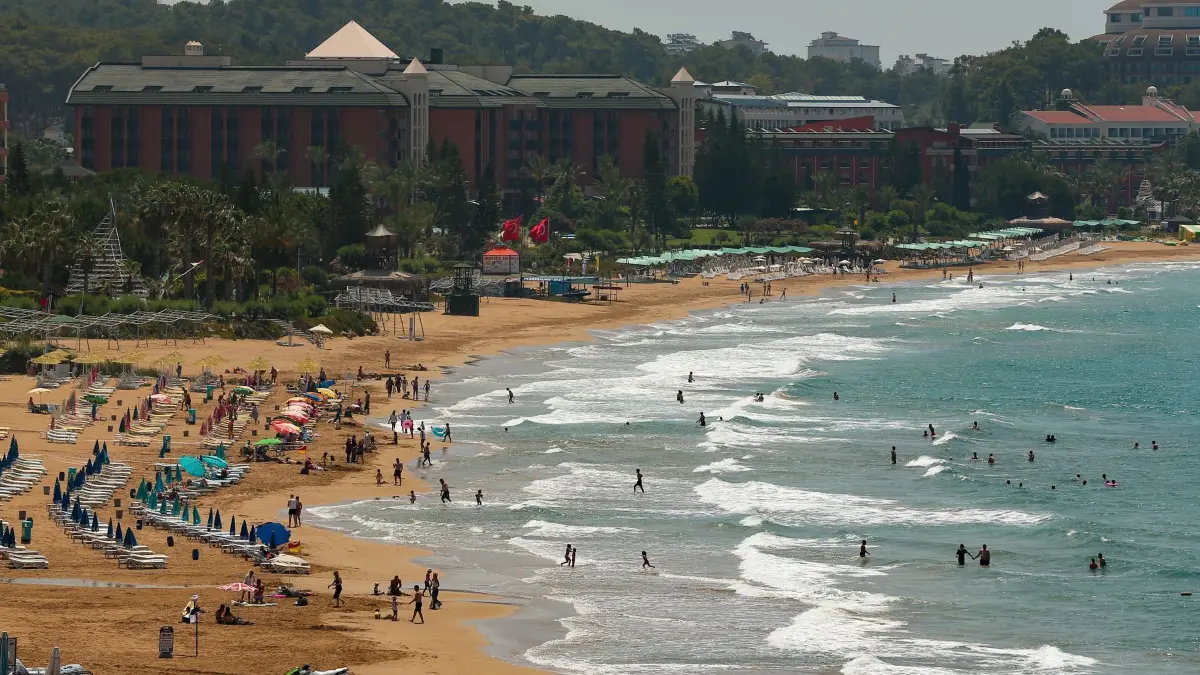 Tourismus in der Türkei: ARCHIV - 20.06.2021, Türkei, Antalya: Touristen besuchen den Strand von Antalya. Hotels in der türkischen Region Antalya, einem bei Urlaubern beliebten Reiseziel, bereiten sich darauf vor, den Betrieb endlich wieder aufzunehmen. (zu dpa: «Ausbeutung im Türkei-Tourismus? Kritik an neuer Arbeitsregel») Foto: Emrah Gurel/AP/dpa +++ dpa-Bildfunk +++