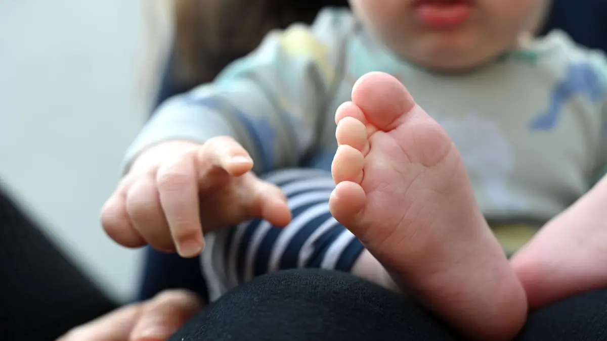 Mütter haben auch Einfluss auf das Geschlecht der Kinder: ARCHIV - 07.05.2025, Sachsen, Leipzig: Ein Baby, das auf dem Schoß seiner Mutter sitzt, zeigt mit der Hand nach vorne. Eine Harvard-Studie kommt zur Annahme, dass das Alter und die Gene der Mütter die Geschlechtsverteilung in der Familie beeinflussen. (zu dpa: «Mütter haben Einfluss auf Geschlecht der Kinder») Foto: Elisa Schu/dpa +++ dpa-Bildfunk +++