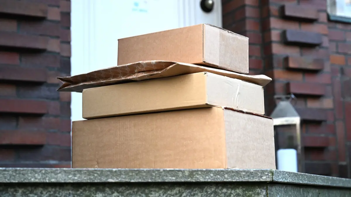 ARCHIV - 15.03.2025, Nordrhein-Westfalen, Düsseldorf: Vier von einem Paketboten gebrachte Pakete liegen vor einer Haustür. Bei der Bundesnetzagentur gingen im ersten Halbjahr 2025 so viele Beschwerden ein wie noch nie. (zu dpa: «So viele Post-Beschwerden wie noch nie») Foto: Wolf von Dewitz/dpa +++ dpa-Bildfunk +++