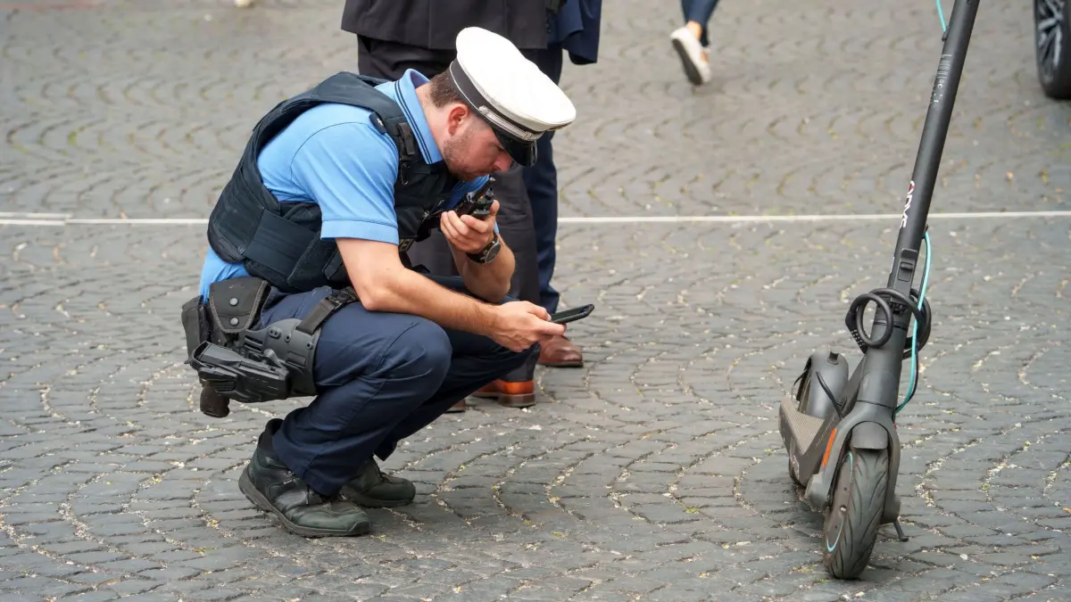 E-Scooterkontrolle in der Innenstadt: 22.07.2025, Hessen, Frankfurt/Main: Ein E-Scooter wird von der Polizei kontrolliert. Die Roller müssen in diesem Bereich geschoben werden, der Verstoß wird mit einer Strafe von 50 Euro geahndet. Die Zahl der Verkehrsunfälle mit E-Scootern ist in den vergangenen Jahren immer weiter angestiegen. Die hessische Polizei will dieser Entwicklung Kontrollen, Prävention, Verkehrserziehung und Aufklärung entgegensetzen. Foto: Andreas Arnold/dpa +++ dpa-Bildfunk +++