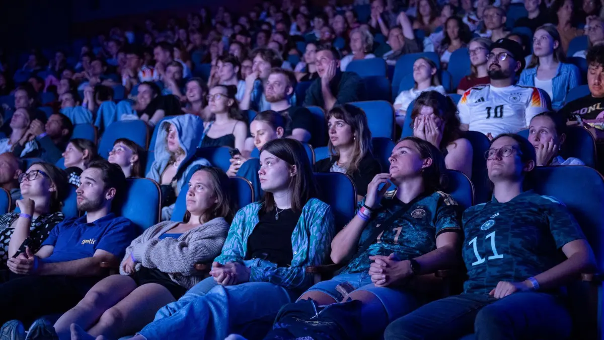 Deutschland - Spanien - Public Viewing: 23.07.2025, Baden-Württemberg, Tübingen: Fußball, Frauen: EM, Deutschland - Spanien, Finalrunde, Halbfinale. Zuschauerinnen und Zuschauer reagieren nach dem Tor zum 0:1 bei einem Public Viewing in einem Kino. Foto: Marijan Murat/dpa +++ dpa-Bildfunk +++