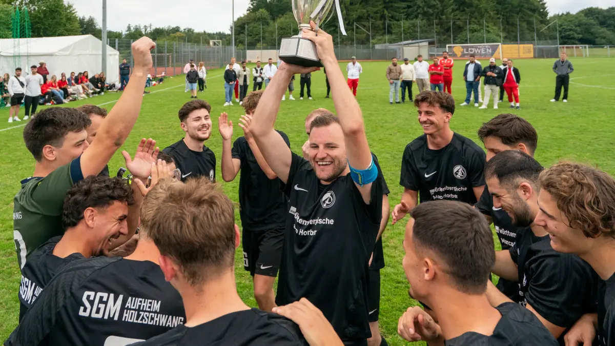 Daniel Stumpp stemmt die Trophäe in die Luft: Der Stürmer der SGM Aufheim/Holzschwang freut sich im Mannschaftskreis über den Sieg im Stadtpokal Ulm/Neu-Ulm. Sein Team hat in Unterweiler den TV Wiblingen mit 3:2 besiegt.