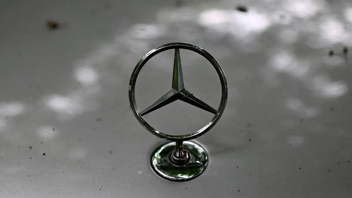 : The logo of German car maker Mercedes-Benz is seen on a car in Dortmund, western Germany, on July 30, 2025. A new trade deal struck between the United States and European Union is good news despite fears it is unbalanced, Mercedes-Benz said after the German carmaker reported a tariff hit of hundreds of millions of euros in the second quarter. (Photo by Ina FASSBENDER / AFP)