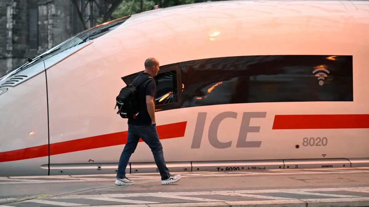 Halbjahres-Bilanz der Deutschen Bahn: 31.07.2025, Nordrhein-Westfalen, Köln: Ein Mann läuft an einem ICE-Zug der Deutschen Bahn vorbei, der im Kölner Hauptbahnhof steht. Die Deutsche Bahn stellt heute auf einer Pressekonferenz ihre Halbjahres-Bilanz vor. Foto: Roberto Pfeil/dpa +++ dpa-Bildfunk +++