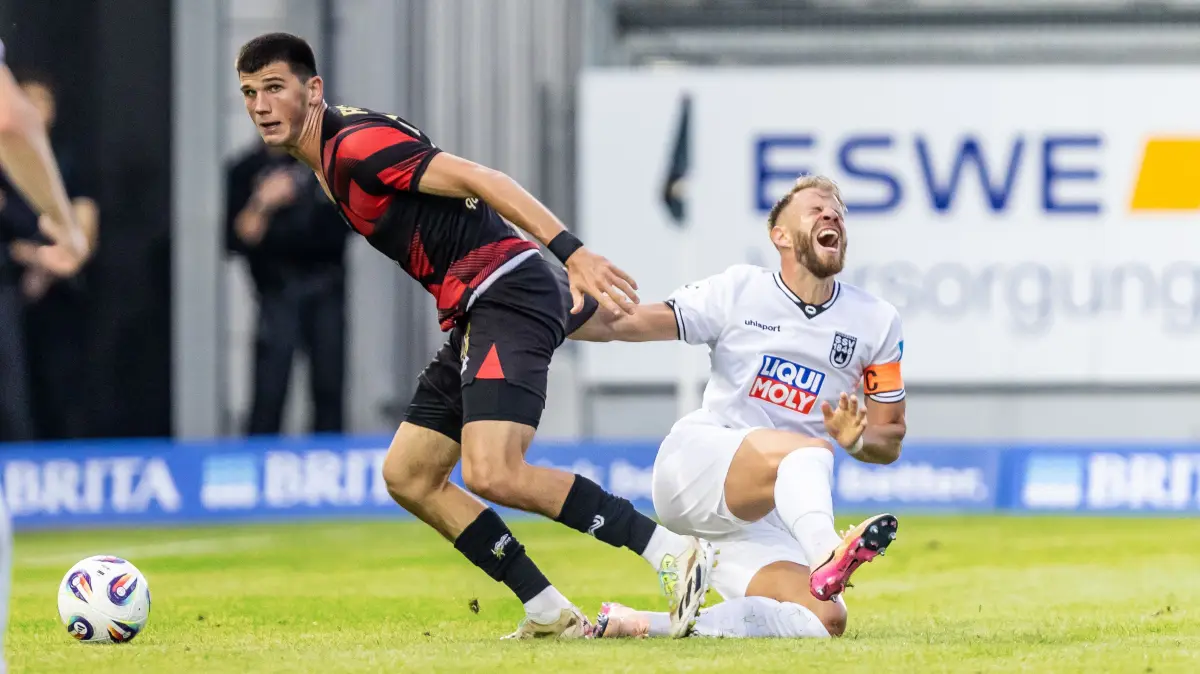 03.08.2025, Fussball, Saison 2025/2026, 3. Liga, BRITA-Arena Wiesbaden, 1. Spieltag, SV Wehen Wiesbaden - SSV Ulm 1846 Fußball, 5 Johannes Reichert (C, SSV Ulm 1846 Fußball, rechts), verletzt sich im Zweikampf mit 28 Moritz Flotho (SV Wehen Wiesbaden) und muss mit der trage verletzt vom Feld.
Foto: Lucca Fundel