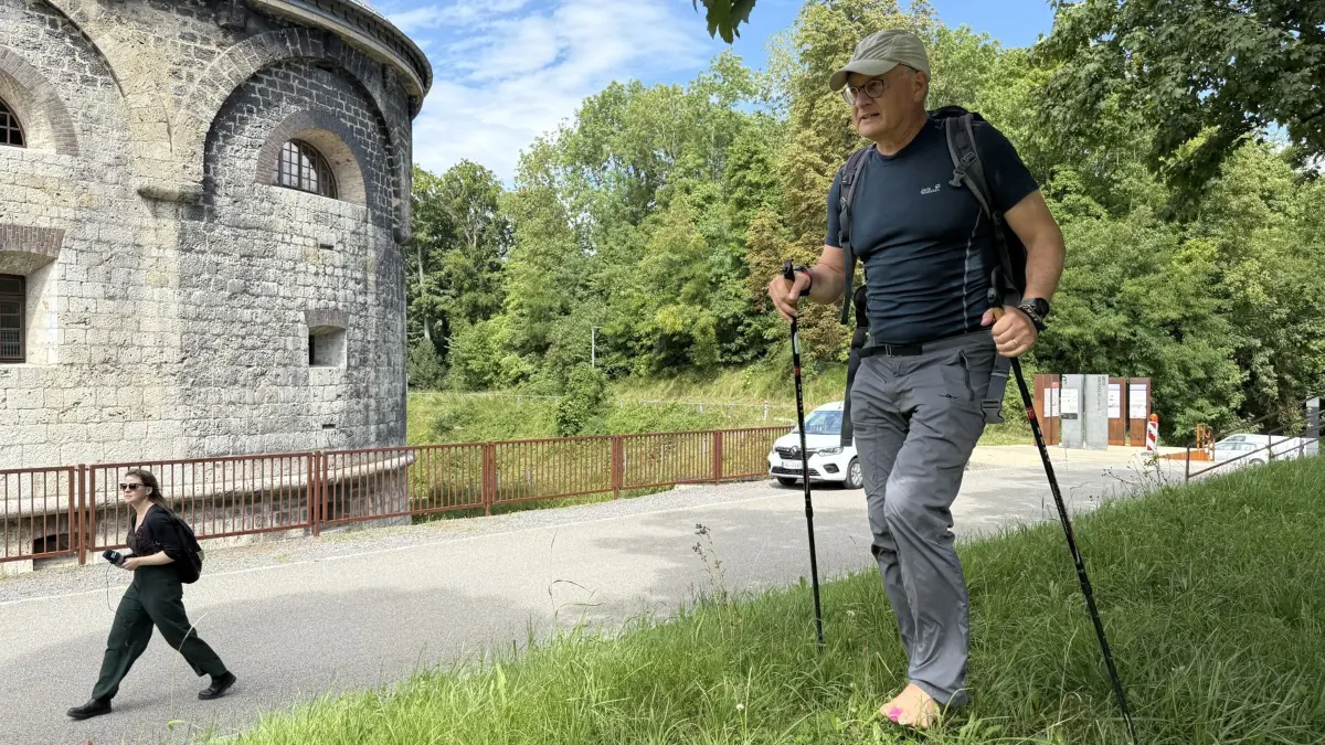 05.08.2025, Baden-Württemberg, Ulm: SPD-Politiker Andreas Stoch Andreas geht an der Wilhelmsburg entlang. Stoch hatte eine Wette verloren und ist von Heidenheim nach Ulm barfuß gewandert. (zu dpa: «Auf nackten Sohlen: Politiker verliert Wette und wandert») Foto: Nico Pointner/dpa +++ dpa-Bildfunk +++