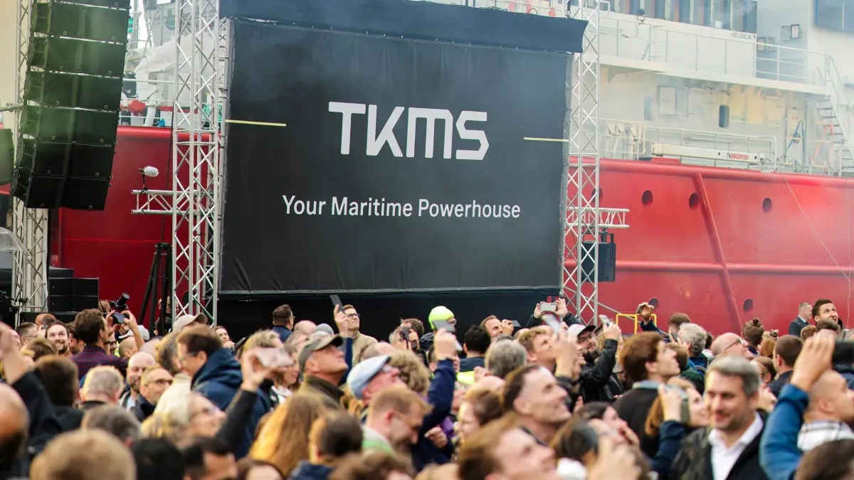 Thyssenkrupp Marine Systems Kiel: ARCHIV - 04.06.2025, Schleswig-Holstein, Kiel: Das neue Logo von Thyssenkrupp Marine Systems (TKMS) hängt auf dem Werftgelände. TKMS präsentierte einen neuen Markenauftritt und eine eigenständige Positionierung des Unternehmens als "maritimes Powerhouse". (zu dpa: «Thyssenkrupp-Aktionäre entscheiden über TKMS-Abspaltung») Foto: Frank Molter/dpa +++ dpa-Bildfunk +++